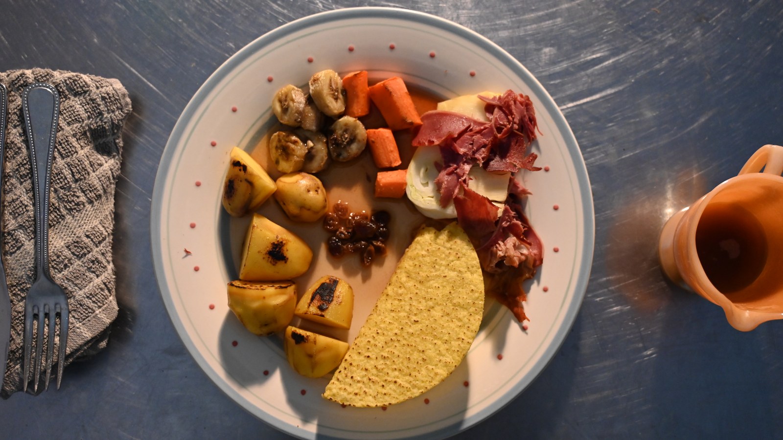 A roast dinner viewed from directly above: a taco shell standing in for Yorkshire pudding, sliced banana for parsnip, raisins in gravy for cranberry sauce, and a rolled slice of ham and fennel for the joint.